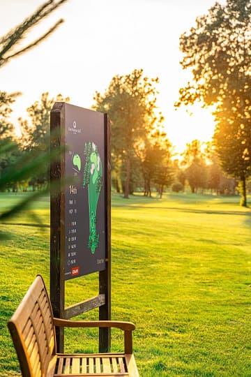 Golf course map and bench on a sunny day